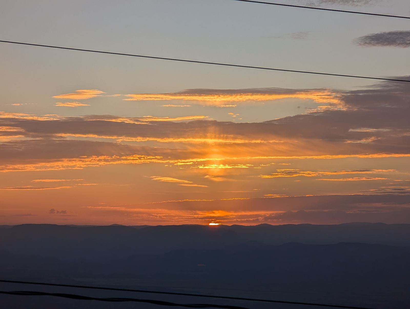 Sunrise with a glowing sun pillar over the Verde Valley, seen from Jerome