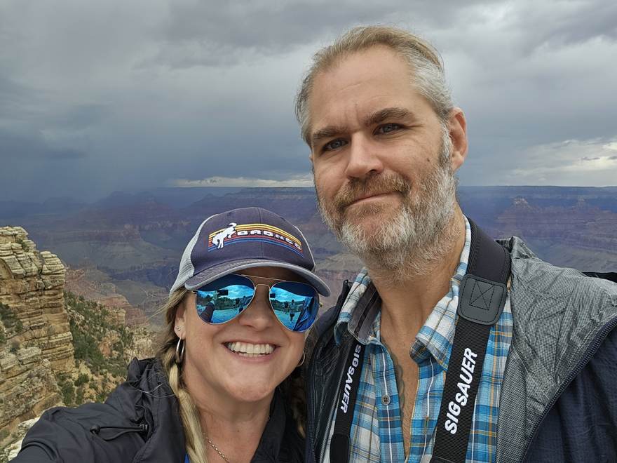 Kelsey and Frank at the rim under storm clouds